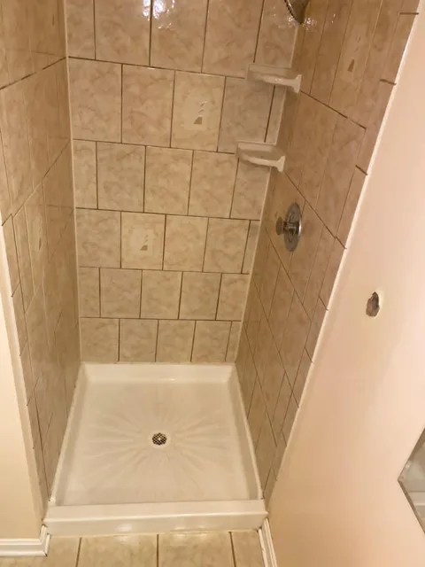 Tiled shower stall scrubbed with the pan bright